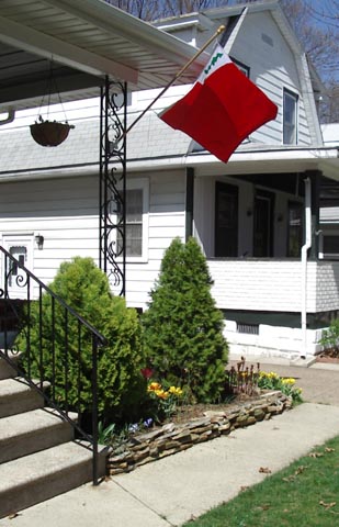 a picture of a house with a flag and flowers